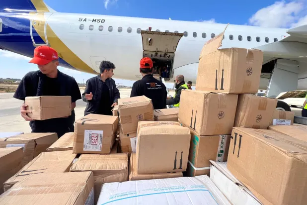 أعضاء جمعية بيوت الشباب الليبية يفرغون المساعدات الطبية التي وصلت بالطائرة إلى مطار الأبرق بعد عاصفة قوية وأمطار غزيرة ضربت ليبيا في الأبرق بليبيا في 12 سبتمبر 2023 (رويترز)