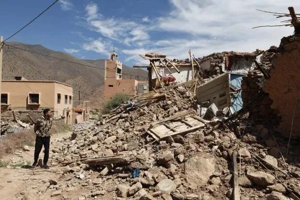 شخص ينظر إلى أنقاض المباني المتضررة إثر زلزال قوي ضرب قرية تلات نيعقوب جنوب مراكش بالمغرب في 12 سبتمبر 2023 (إ.ب.أ)