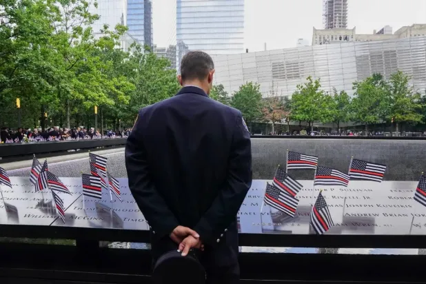 رجل إطفاء أميركي أمام نصب تذكاري لضحايا هجمات 11 سبتمبر (أ.ف.ب)