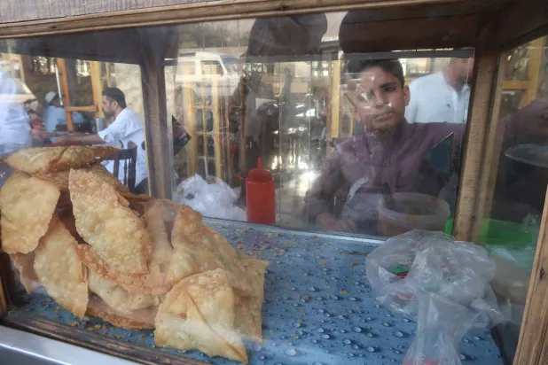 الطفل عبيد حسين ترك المدرسة للعمل مع عائلته في صناعة الخبز بباكستان (إ.ب.أ)