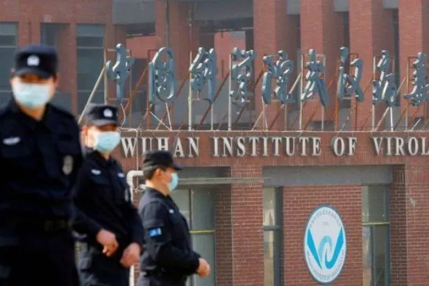 أفراد أمن أمام بوابة مختبر ووهان الصيني (أرشيفية - رويترز)
