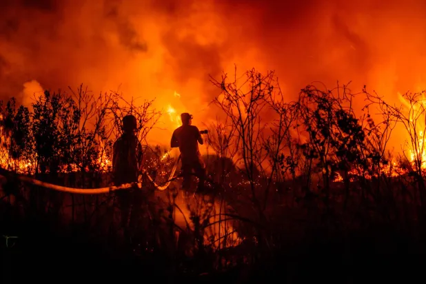 رجال الإطفاء يحاولون إخماد حريق في أرض الخث في أوغان إلير جنوب سومطرة في 12 سبتمبر الحالي (أ.ف.ب)