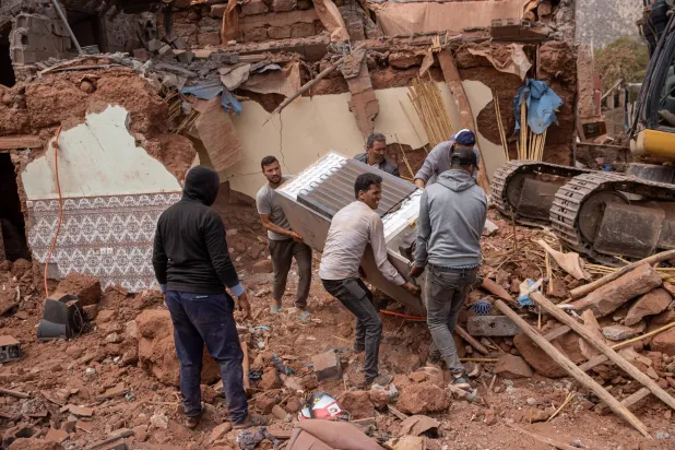 مراکش کے شہر ویرکان میں زندہ بچ جانے والوں کی تلاش کے دوران 12 ستمبر 2023 کو رہائشی افراد منہدم عمارت سے ایک ریفریجریٹر ہٹا رہے ہیں (ای پی اے) 