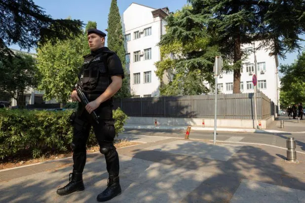 عنصر شرطة يحمي المحكمة العليا في بودغوريتشا عاصمة مونتينيغرو قبل المحاكمة التي تبدأ لعدد من المتهمين بتهم التورط في محاولة انقلاب في يوم الانتخابات العام الماضي (2016) في 19 يوليو 2017 (رويترز)