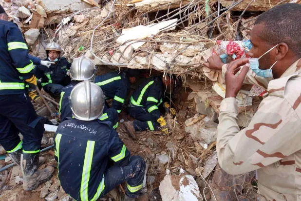Fire and rescue teams search for survivors among the rubble of a collapsed building following floods that struck the city of Derna in eastern Libya, September 14, 2023 (AFP)

 