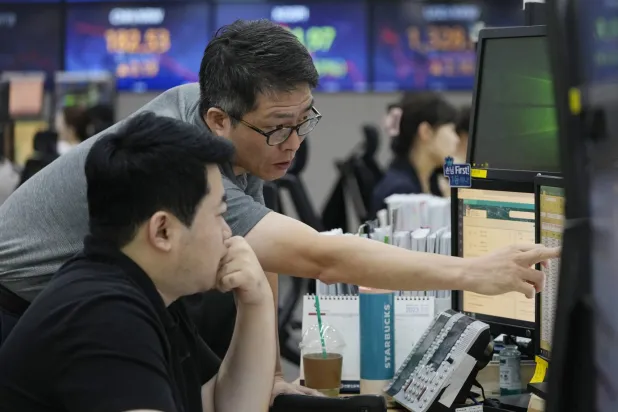 متداولون يتابعون حركة الأسهم على مؤشر «كوسبي» في بورصة كوريا الجنوبية بالعاصمة سيول (أ.ب)