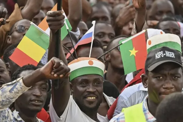 مواطن من النيجر يرفع أعلام بلده ومالي وبوركينا فاسو مع العلم الروسي (وكالات أنباء)