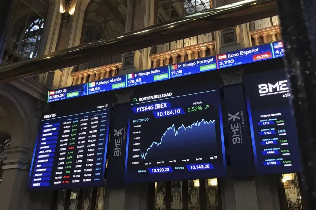 شاشة عملاقة تعرض تحركات الأسهم على مؤشر «إيبكس 35» الإسباني في بورصة مدريد (إ.ب.أ)