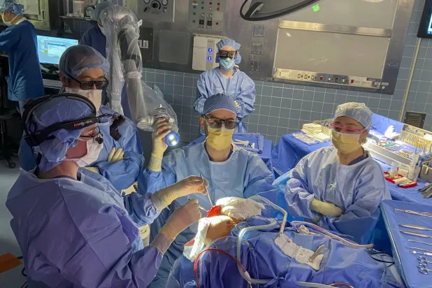 فريق الجراحين لوضع «كوة» مصنعة على جمجمة المصاب تاكر مار