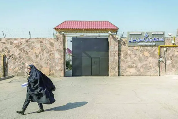 ایک ایرانی خاتون تہران میں قرچک جیل کے خواتین والے حصے کے دروازے سے گزر رہی ہے (میزان)