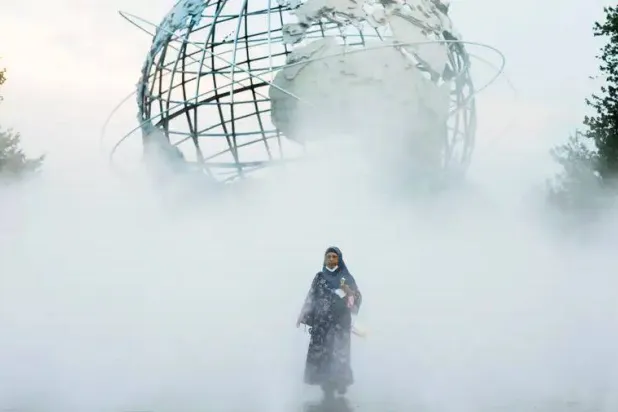 سيدة تقف في متنزه فلاشينغ ميدوز كورونا بارك في نيويورك (رويترز)