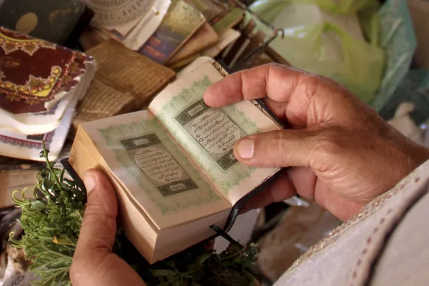 ایک شخص قرآن پاک کا نسخہ تھامے ہوئے ہے (آرکائیو - اے پی)