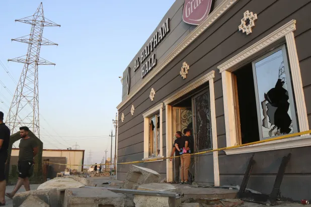 أشخاص يتجمعون في موقع الحريق بقضاء الحمدانية (أ.ب)