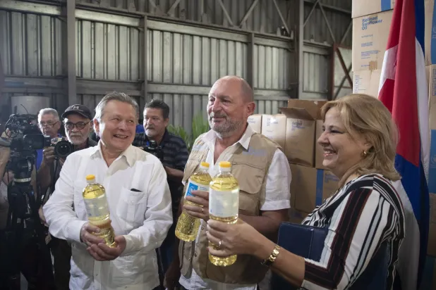 نا تيريسيتا غونزاليس (يمين) نائبة وزير التجارة الخارجية والاستثمار الأجنبي الكوبية إتيان لاباندي (وسط) ممثل برنامج الأغذية العالمي في كوبا وفيكتور كورونيلي (يسار) السفير الروسي لدى كوبا يحضرون حفلاً بمناسبة تبرع الاتحاد الروسي بالزيت النباتي في هافانا بكوبا في 27 سبتمبر 2023 (إ.ب.أ)