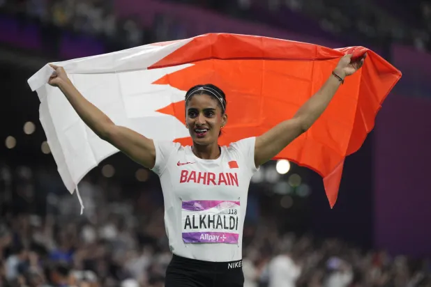 هاجر صاحبة برونزية سباق 100 م مُلتفة بعلم البحرين (أ.ب)