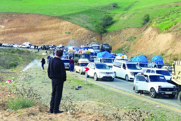 قافلة طويلة من السيارات التي تُقلّ فارّين من كاراباخ تنتظر عبور الحدود إلى أرمينيا في 28 سبتمبر (أ.ف.ب)