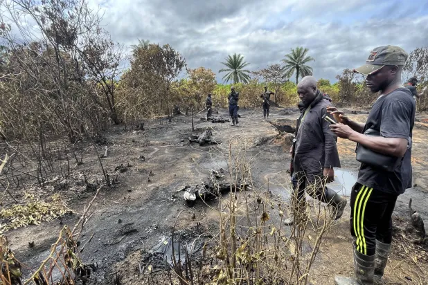 عناصر أمن وسكان محليون ينظرون في الجثث المتفحمة لضحايا انفجار مصفاة غير قانونية في إيموهوا في دلتا النيجر بنيجيريا في 3 أكتوبر 2023 (أ.ب)