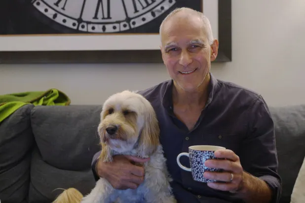 البروفيسور منجي الباوندي الفرنسي المولد والتونسي الأصل الفائز بجائزة «نوبل» للكيمياء مع ثلاثة علماء آخرين يجلس في منزله برفقة كلبه (رويترز)