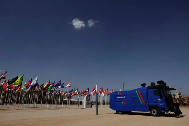 مركبة مدرعة من قوات الأمن الوطني المغربية تمر عبر المدخل الرئيسي لمكان الاجتماعات السنوية (رويترز)