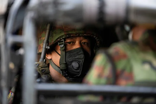 جندي من الجيش في ميانمار يجلس داخل مركبة عسكرية (رويترز)