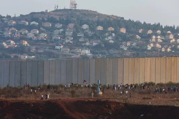People hold Palestinian flags during a rally to express solidarity with Palestinians, in Kfar Kila village near the border with Israel, southern Lebanon, October 8, 2023. (Reuters)