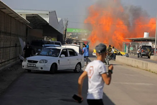 Palestinians and militants from the Ezzedine al-Qassam Brigades run towards the Erez crossing between Israel and north Gaza Strip (AFP)