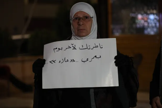 مشاركة تحمل لافتة تعبر بها عن انتظار قريبها المعتقل لدى النظام السوري (الشرق الأوسط)