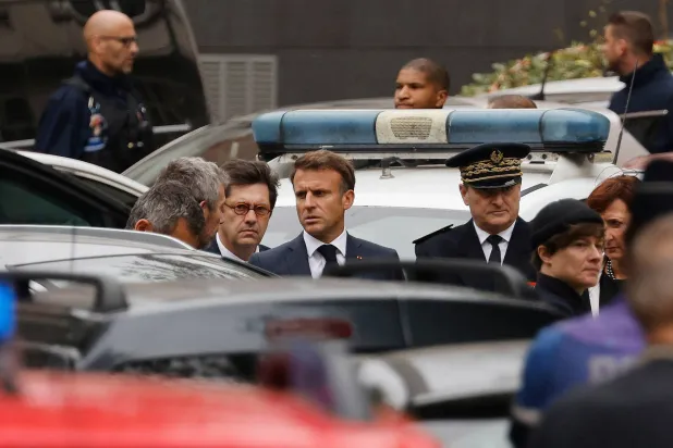 ماكرون لدى وصوله إلى مدرسة غامبيا الثانوية في مجدين أراس بعد عملية قتل مدرس وإصابة اثنين آخرين بجروح الجمعة (أ.ف.ب)