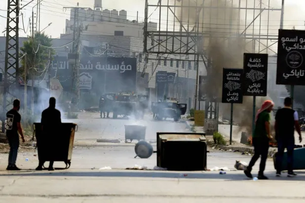 A Palestinian youth clashes with Israeli security forces at the Huwwara checkpoint at the southern entrance of Nablus (AFP)