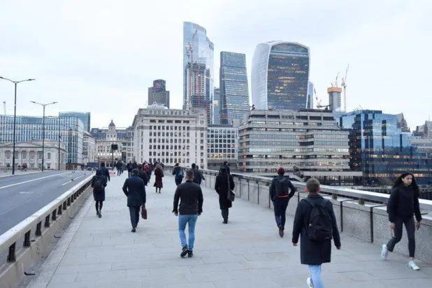 موظفون يعبرون جسر لندن خلال ساعة الذروة الصباحية (رويترز)