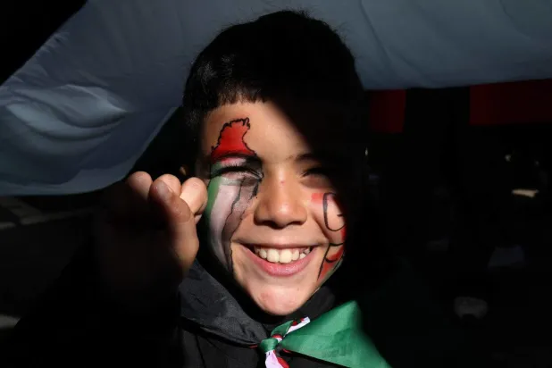 Londra’da Filistin’e destek yürüyüşü sırasında yüzünde Filistin bayrağı olan küçük bir çocuk (AFP)