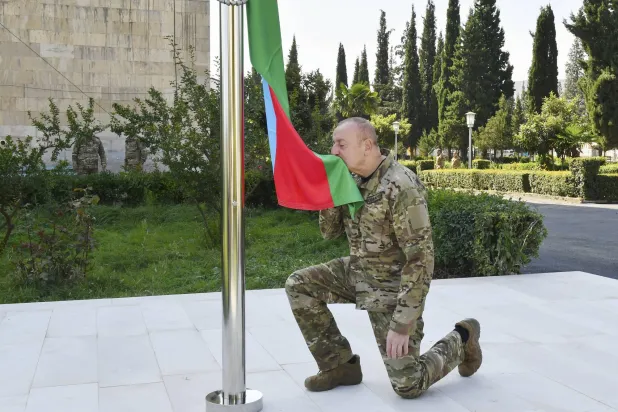 الرئيس الأذربيجاني إلهام علييف يرفع علم بلاده في عاصمة كاراباخ الأحد (إ.ب.أ)