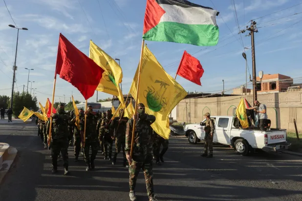 عناصر من «حركة النجباء» الشيعية العراقية يرفعون العلم الفلسطيني وأعلاماً أخرى خلال تجمع في بغداد 8 أكتوبر الحالي (أ.ف.ب)