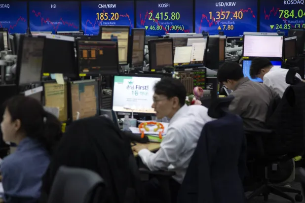 متداولون يتابعون حركة هبوط الأسهم المتواصلة على شاشات في بورصة العاصمة الكورية سيول (إ.ب.أ)