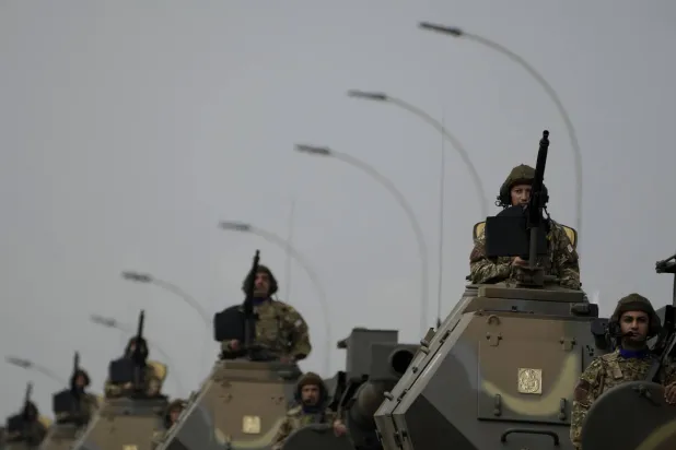 جنود قبرصيون يظهرون على مركبات عسكرية خلال عرض عسكري في نيقوسيا (أ.ب)
