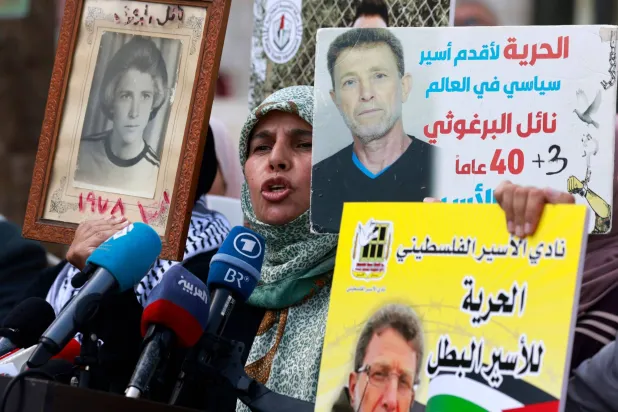 عائلات سجناء فلسطينيين في السجون الإسرائيلية خلال مظاهرة تطالب بالإفراج عنهم والتعبير عن تضامنهم مع الفلسطينيين في غزة بمدينة رام الله بالضفة الغربية في 22 أكتوبر 2023 (أ.ف.ب)