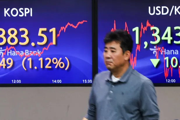 متداول يتابع تحركات الأسهم في بورصة كوريا الجنوبية بالعاصمة سيول (إ.ب.أ)