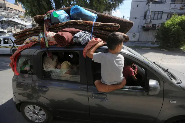 فلسطينيون ينزحون من منازلهم  في شمال غزة (13 أكتوبر) هرباً من القصف الإسرائيلي (رويترز)