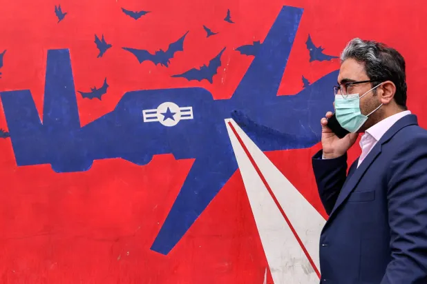 إيراني يمر من أمام جدارية على حائط السفارة الأميركية السابقة في طهران اليوم (أ.ف.ب)