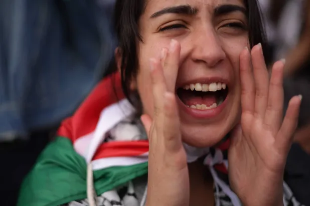 متظاهرة خلال مسيرة في واشنطن تطالب بوقف إطلاق النار في غزة (أ.ف.ب)