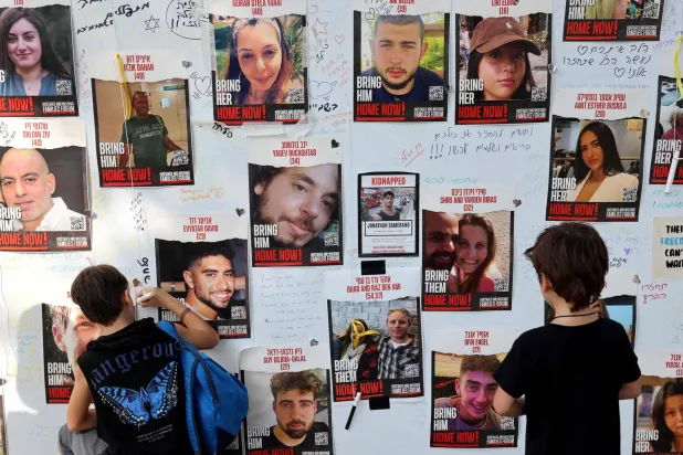 رسائل تُركت على جدار في مدينة تل أبيب تظهر الرهائن الإسرائيليين الذين احتجزهم مسلحو «حماس» ومطالب بإطلاق سراحهم (أ.ف.ب)