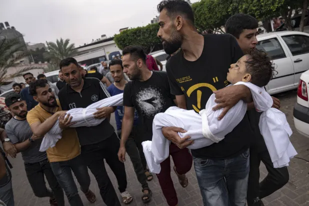 يحملون جثامين أطفال قُتلوا في القصف الإسرائيلي على خان يونس بقطاع غزة نهاية أكتوبر (أ.ب)