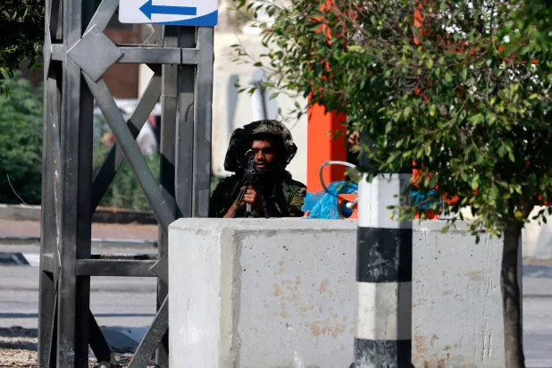 جندي إسرائيلي يتخذ موقعه على طول الطريق بين مدينتي نابلس وطولكرم بالضفة الغربية (أ.ف.ب)