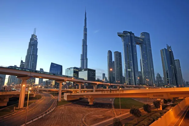 قطار مترو يمر في أفق المدينة مع برج خليفة، أطول برج في العالم يظهر في المركز، في دبي، الأحد 12 نوفمبر 2023 (أسوشيتد برس)