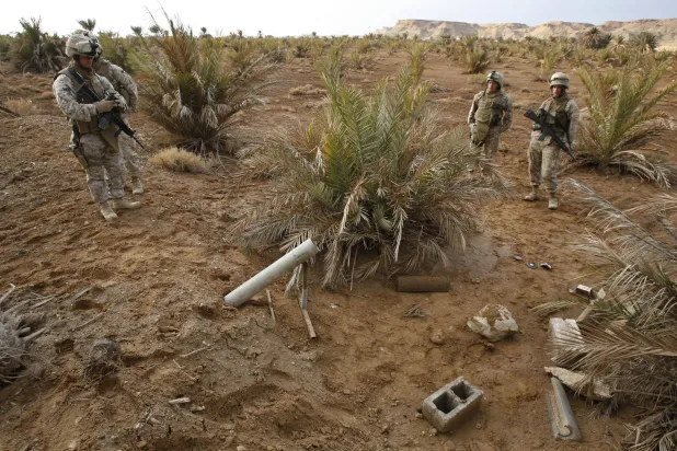 امریکی میرینز ایک گھریلو ساختہ راکٹ لانچر کا معائنہ کر رہے ہیں جو مغربی عراق کے ایک فوجی اڈے کے قریب صحرا میں پایا گیا تھا (آرکائیوز - روئٹرز)