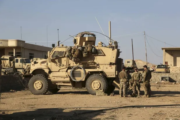 جنود أميركيون يقفون خارج مركبتهم المدرعة جنوب الموصل (أرشيفية - أ.ب)