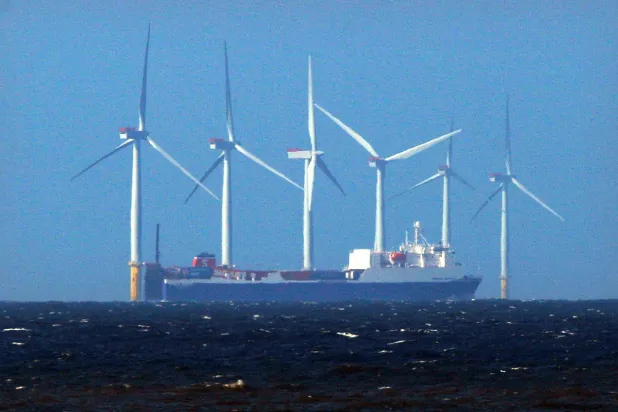 سفينة تعبر محطة لتوليد الطاقة من حركة الرياح  في شمال بريطانيا (رويترز)