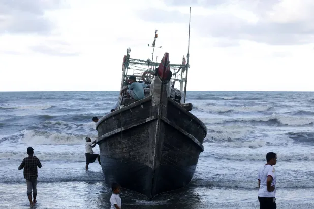 مركب خشبي يحمل لاجئين من الروهينغا إلى ساحل إندونيسيا الأحد (إ.ب.أ)