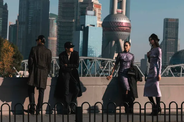 مشاة فوق جسر في مدينة شنغهاي الصينية في يوم مشمس (إ.ب.أ)