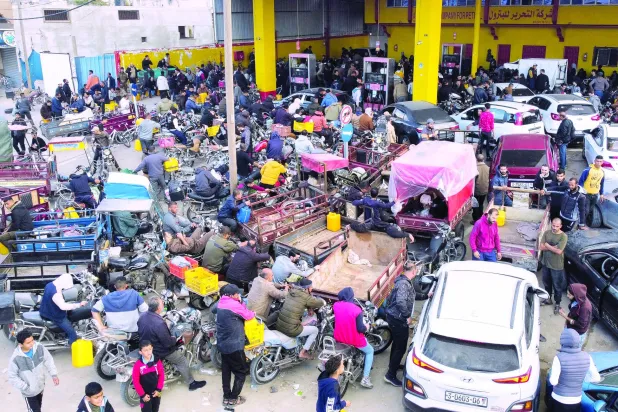 گزشتہ روز جنوبی غزہ کے شہر خان یونس میں جنگ بندی کے دوران فلسطینی اپنی کاروں میں ایندھن بھرنے کا انتظار کر رہے ہیں (روئٹرز)